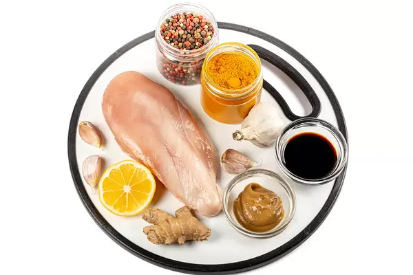 Chicken fillet with spices, ginger and lemon on a cutting board