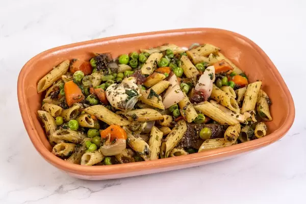 Chicken meat with Bacon and vegetables and pasta above white background