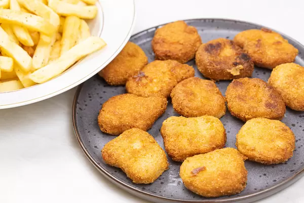 Chicken Nuggets served with french fries on the plate