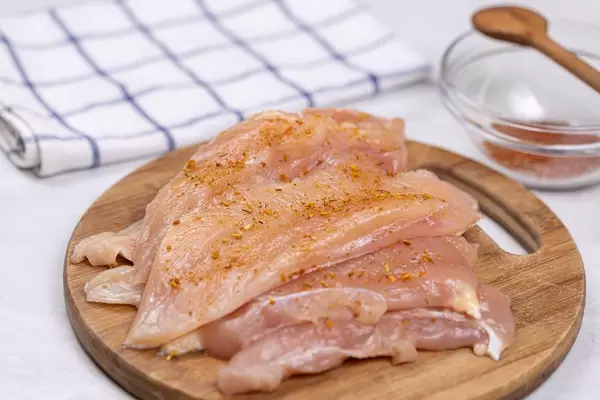 Chicken Raw Breasts spiced with Paprika and prepared for frying