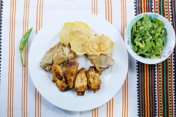Chicken wings and fried potatoes with lettuce salad