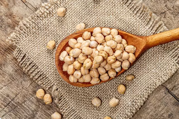 Chickpeas in a wooden spoon on burlap. Top view (Flip 2019)