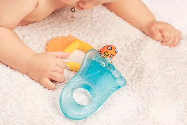 Child boy on a light blanket with toys