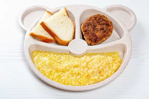 Children's bowl with cereal, a chop and bread