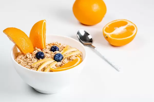 Children's breakfast with oatmeal porridge and fresh fruit in the shape of a rabbit face