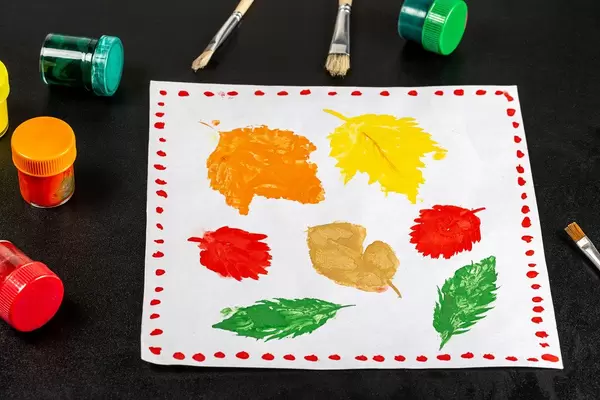 Children's drawing of multicolored autumn leaves with paints