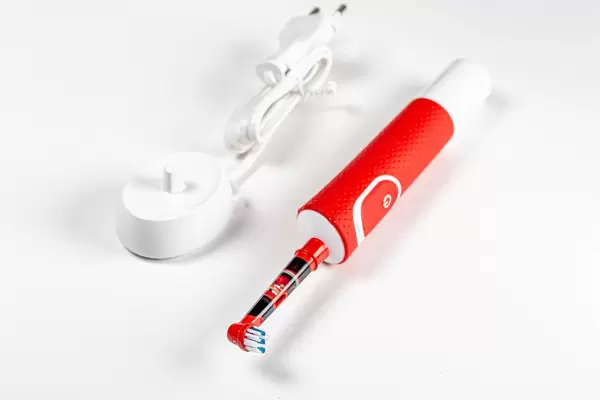 Children's electric toothbrush with charger on a white background