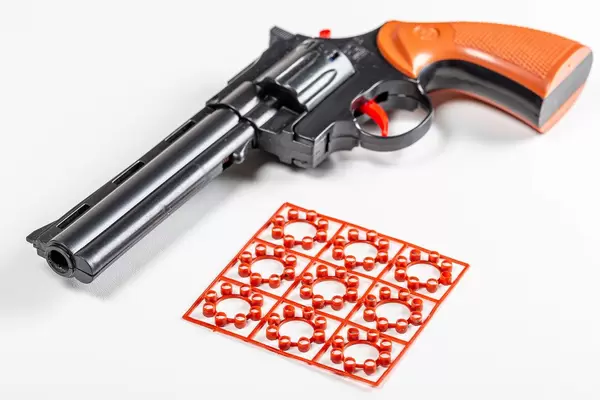 Children's pistol with cartridges on a white background