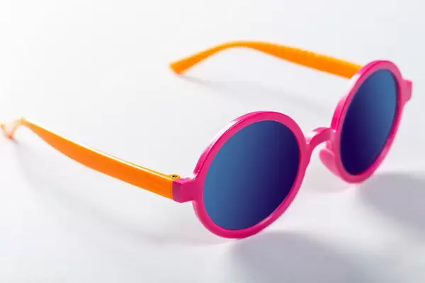 Children's sunglasses in bright colors on white background