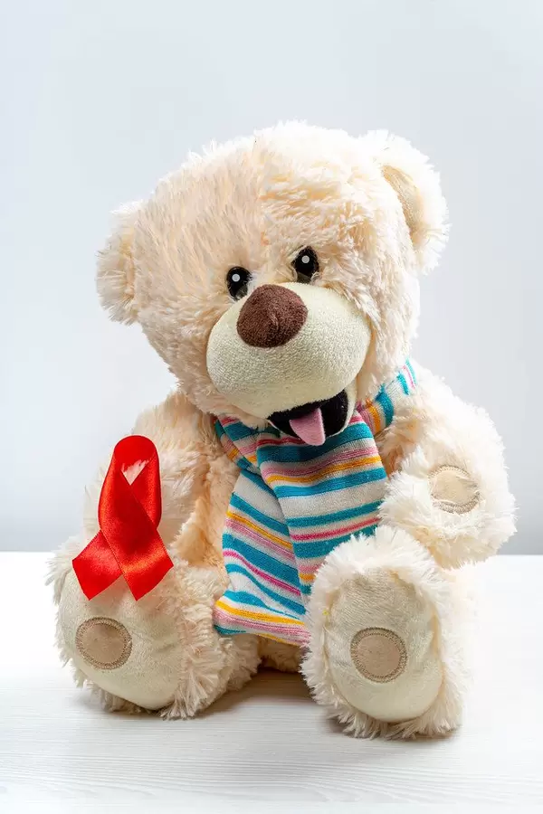 Children's toy bear with red ribbon as a symbol of the fight against children's cancer (Flip 2019)