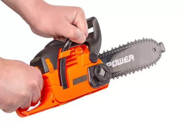 Children's toy chainsaw in the hands of a man, game concept