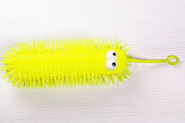 Children's yellow toy on white wooden background