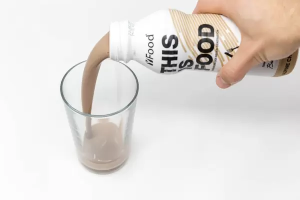 Chilled chocolate milk drink is poured into glass