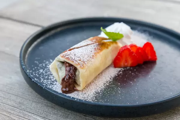 Chimichanga: gebratene, mit Schokolade und Erdbeeren gefüllte Tortilla. Villa Vegana, Selva