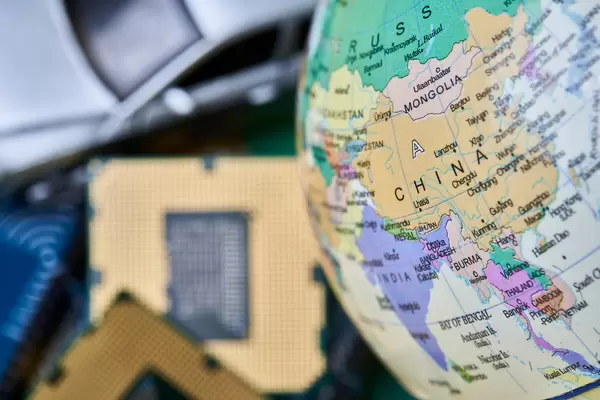 China map on the globe and pile of microchips with car toy. Concept of car-chip shortage in China