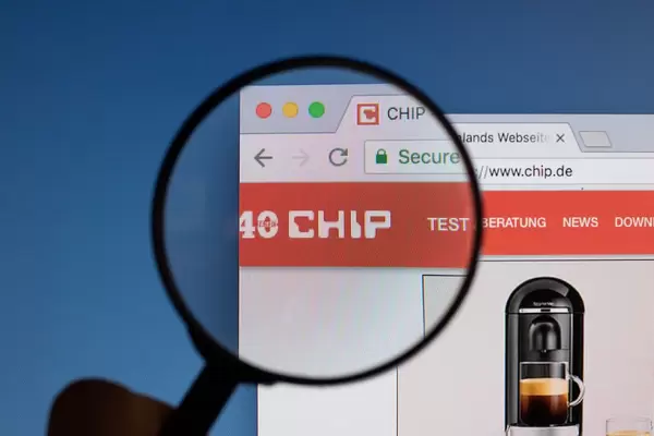 Chip.de Logo am PC-Monitor, durch eine Lupe fotografiert