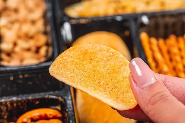 Chips in a woman's hand close - up on the background of beer snacks (Flip 2019)