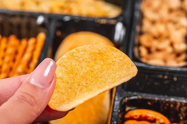 Chips in a woman's hand close - up on the background of beer snacks