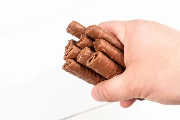 Chocolate Bars in the hand above white background (Flip 2020)