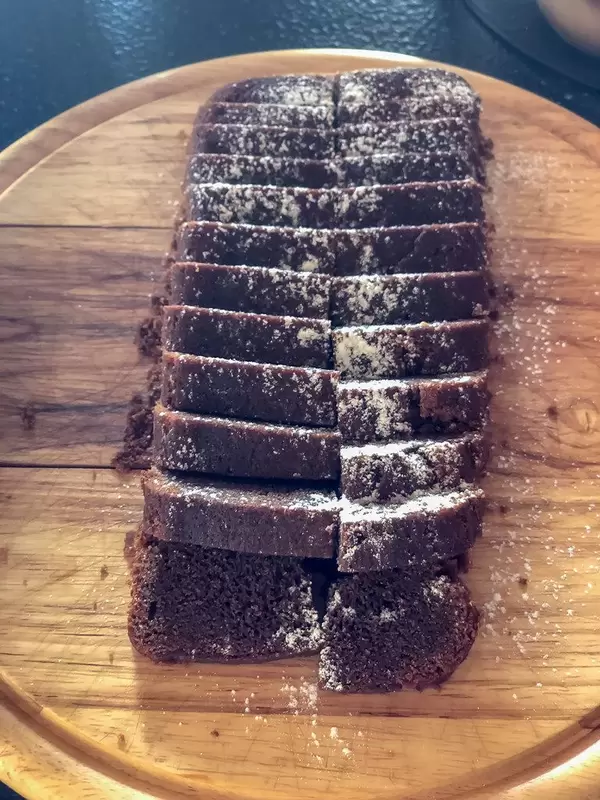 Chocolate cake with powdered sugar on a cutting board