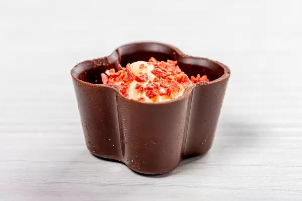 Chocolate candy with white cream and pieces of strawberries (Flip 2019)
