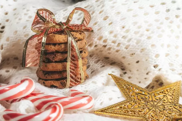 Chocolate chip cookies with Lollipop cane on white knitted background