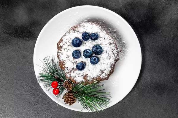 Chocolate cupcake sprinkled with powdered sugar with fresh blueberries. Top view (Flip 2019)