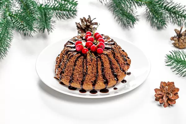 Chocolate cupcake with red currants on Christmas background