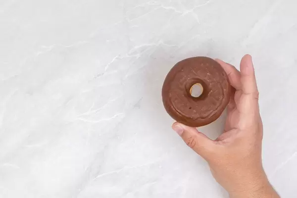 Chocolate Donut in the hand with copy space