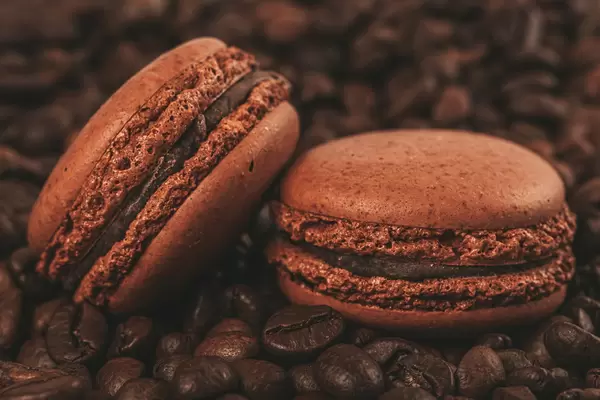 Chocolate macaroons and coffee beans, close-up