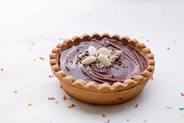 Chocolate torte with sprinkles on a white background