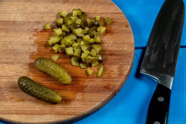 Chopped Pickles on the round wooden board with knife (Flip 2020)