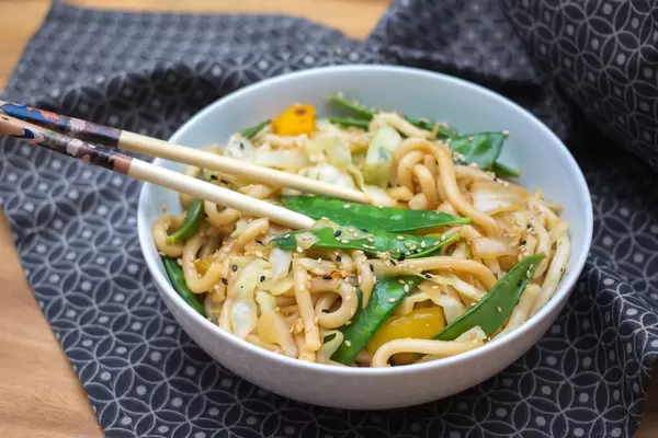 Chow Mein Nudeln mit Grünen Bohnen und Sesam in einer Schale mit Essstäbchen