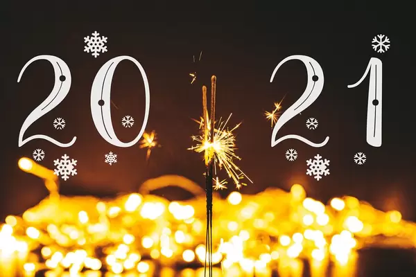 Christmas and new year background with glowing sparklers and golden bokeh