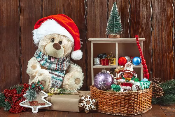 Christmas background with a teddy bear, Christmas toys and gifts on a wooden table. The concept of a children's holiday, family celebration