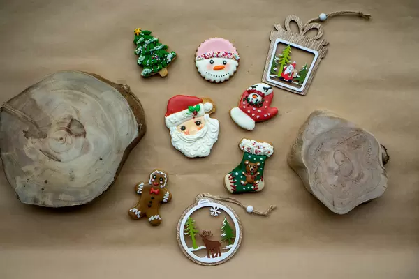 Christmas Background with different Gingerbread Christmas Cookies, Cut Tree Trunks and Wooden Christmas Decorations on a Baking Paper