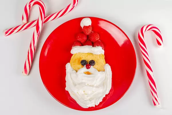 Christmas breakfast pancake santa claus with lollipop sticks, top view