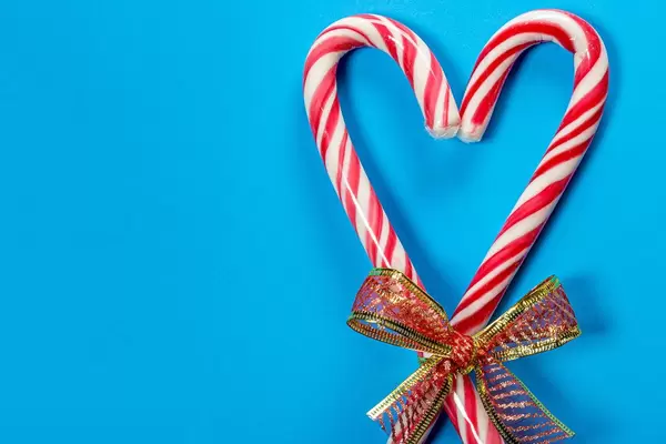 Christmas candy canes heart shaped on blue background (Flip 2019)