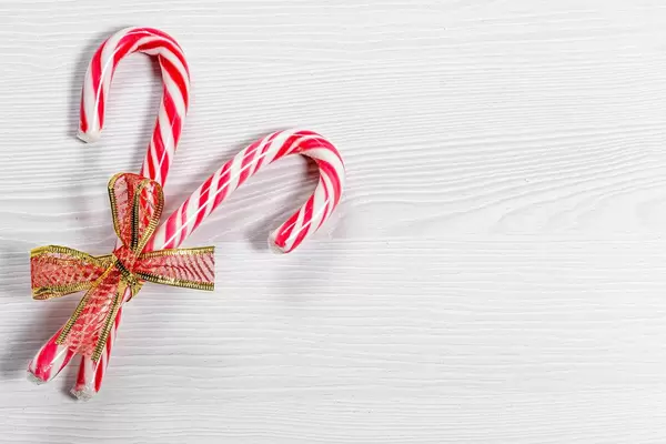 Christmas candy canes on a white wooden background