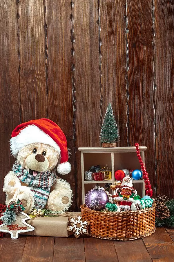 Christmas composition with a soft toy bear, Christmas toys, a Christmas tree and gifts on a wooden table. The concept of a family holiday, New Year's traditions