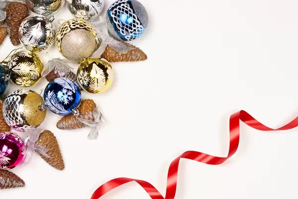 Christmas composition with Xmas gifts, toys, pine cones and ribbon on white background