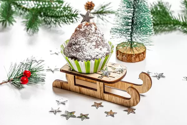 Christmas cupcake on a sled and a tree on a white background
