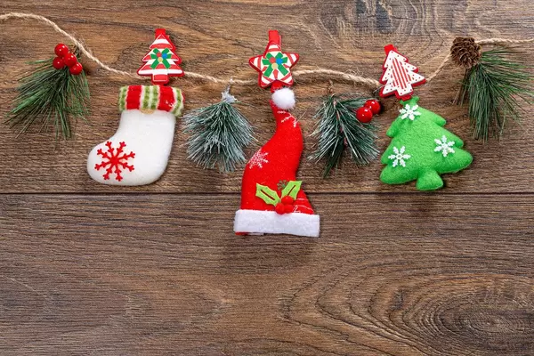 Christmas decor hanging on string on brown wooden background (Flip 2019)