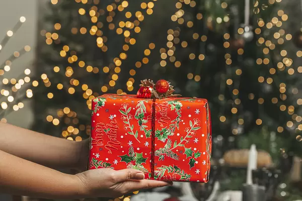 Christmas gift in female hands, the concept of congratulations to loved ones