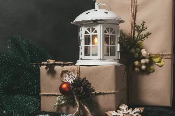 Christmas gifts with lantern and burning candles on black background