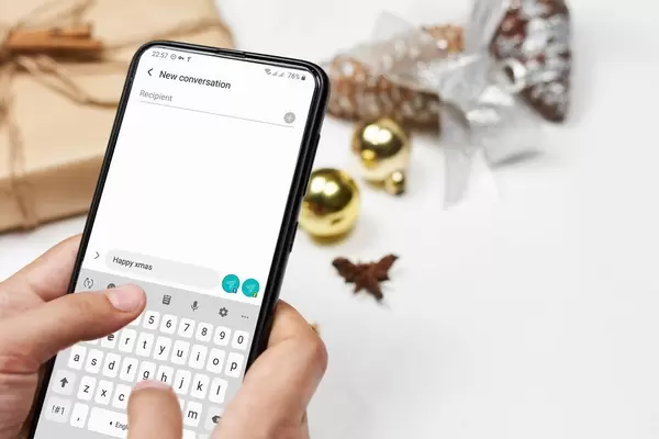 Christmas in lockdown. A female sending Christmas message to friends over the Xmas decorations