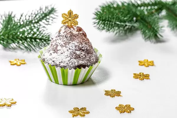 Christmas muffin with Christmas tree branches and snowflakes on a white background (Flip 2019)
