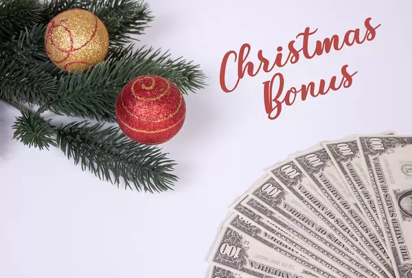 Christmas ornaments and dollar banknotes with Christmas Bonus text