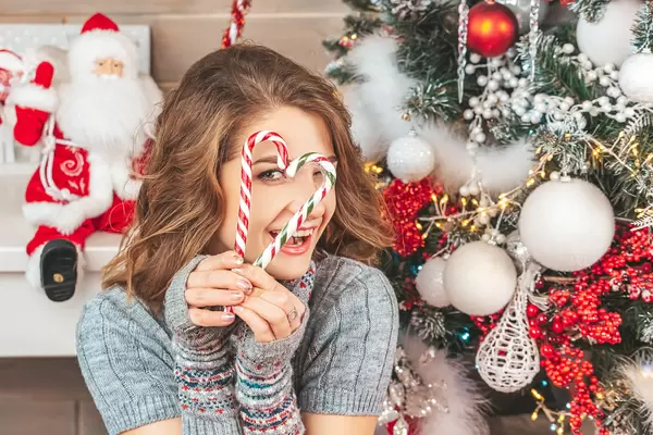 Christmas portrait of a cheerful girl with candy heart in his hands