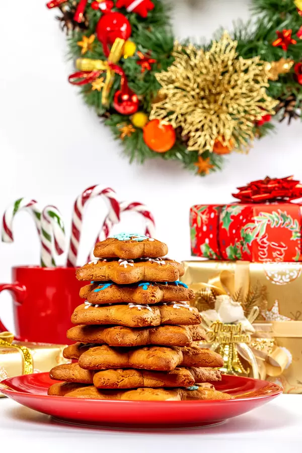 Christmas tree made of gingerbread cookies with gifts, sweets and wreath